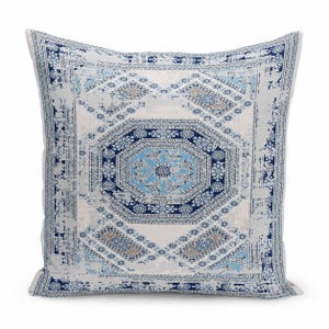 May include: A square throw pillow featuring a central octagonal medallion pattern in shades of navy blue, light blue, and white. The design includes intricate geometric and floral motifs with a distressed, weathered texture throughout the fabric.
