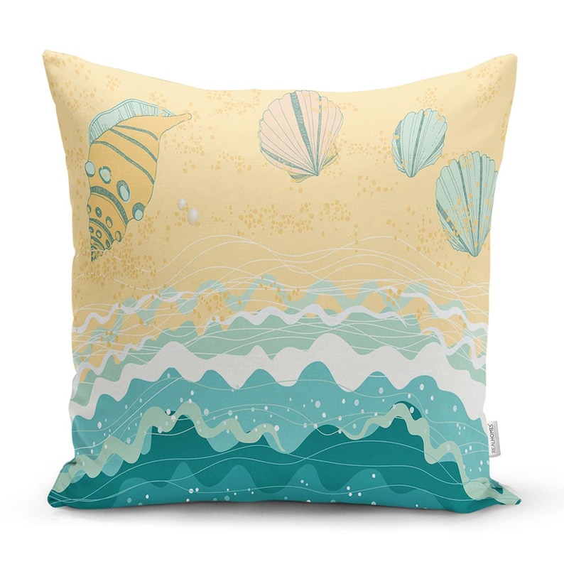 Peut inclure: Un coussin de d&eacute;coration jaune et bleu avec une sc&egrave;ne de plage repr&eacute;sentant des coquillages et des vagues. Le coussin a un fond blanc avec un motif de vagues bleu clair et vert.