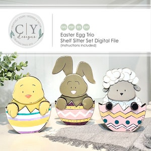 May include: A digital file set of three Easter egg shelf sitters. The set includes a chick, a bunny, and a lamb, each sitting inside a colourful, decorated egg. The eggs have a pink, yellow, and purple colour scheme with white and blue accents.