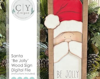 Könnte beinhalten: Ein Holzschild mit einem gemalten Bild von Santa Claus' Gesicht und dem Text "Be Jolly". Das Schild ist in einem braunen Holzrahmen gerahmt.