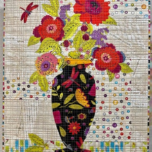 May include: A colorful floral arrangement in a black vase with a floral pattern. The vase is sitting on a white background with a patterned border.