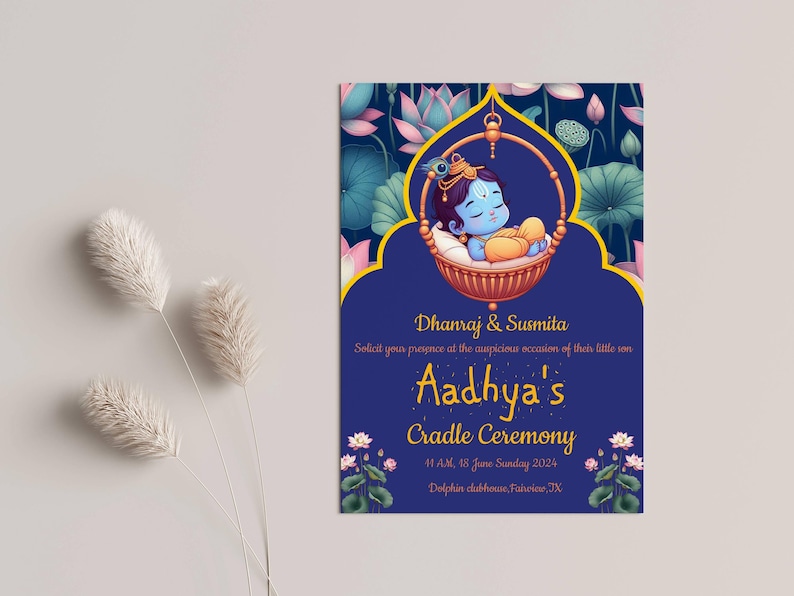 May include: A blue and gold invitation card with a floral design. The card announces a cradle ceremony for a baby boy named Aadhya. The text on the card reads "Dhanraj & Susmita Solicit your presence at the auspicious occasion of their little son Aadhya's Cradle Ceremony 4:1 AM, 18 June Sunday 2024 Dolphin clubhouse, Fuisine, TX."