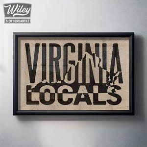 May include: Framed wall art with the words "VIRGINIA LOCALS" in a distressed, vintage style. The black text is set against a tan background, with a map outline of Virginia. The frame is black, and the artwork has a rustic, aged appearance.