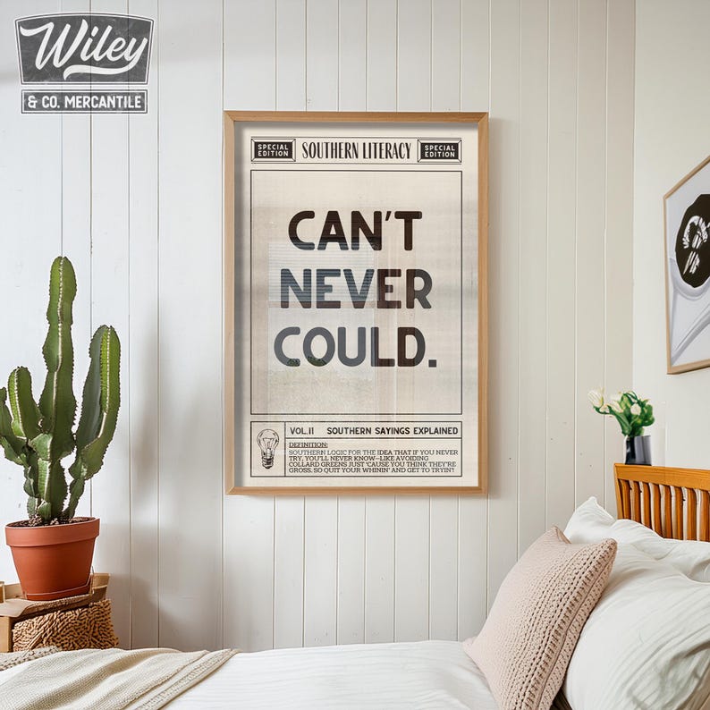 Pu&ograve; includere: Un poster in stile vintage con un designo in bianco e nero. Il poster presenta il testo "CAN'T NEVER COULD." e una descrizione del detto del sud. Il poster &egrave; incorniciato in una cornice di legno chiaro ed &egrave; appeso a un muro bianco.