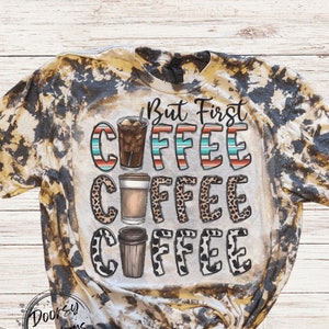 May include: A bleached tie-dye t-shirt with a brown and black pattern. The shirt features the text "But First Coffee" with three coffee cups in different styles.