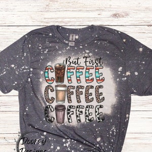 May include: A gray t-shirt with a bleach-splattered design featuring the text "But First Coffee" with three coffee cups in different styles.