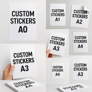 May include: A collection of white custom stickers in various sizes, including A0, A1, A2, A3, and A4. The stickers feature bold black text that reads "CUSTOM STICKERS" and size designations.