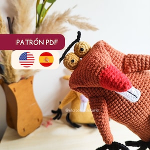 Puede incluir: Patrón de crochet PDF para un personaje de dibujos animados con pelaje naranja, nariz roja y ojos negros. El patrón está disponible en inglés y español. La imagen muestra el personaje de crochet terminado.