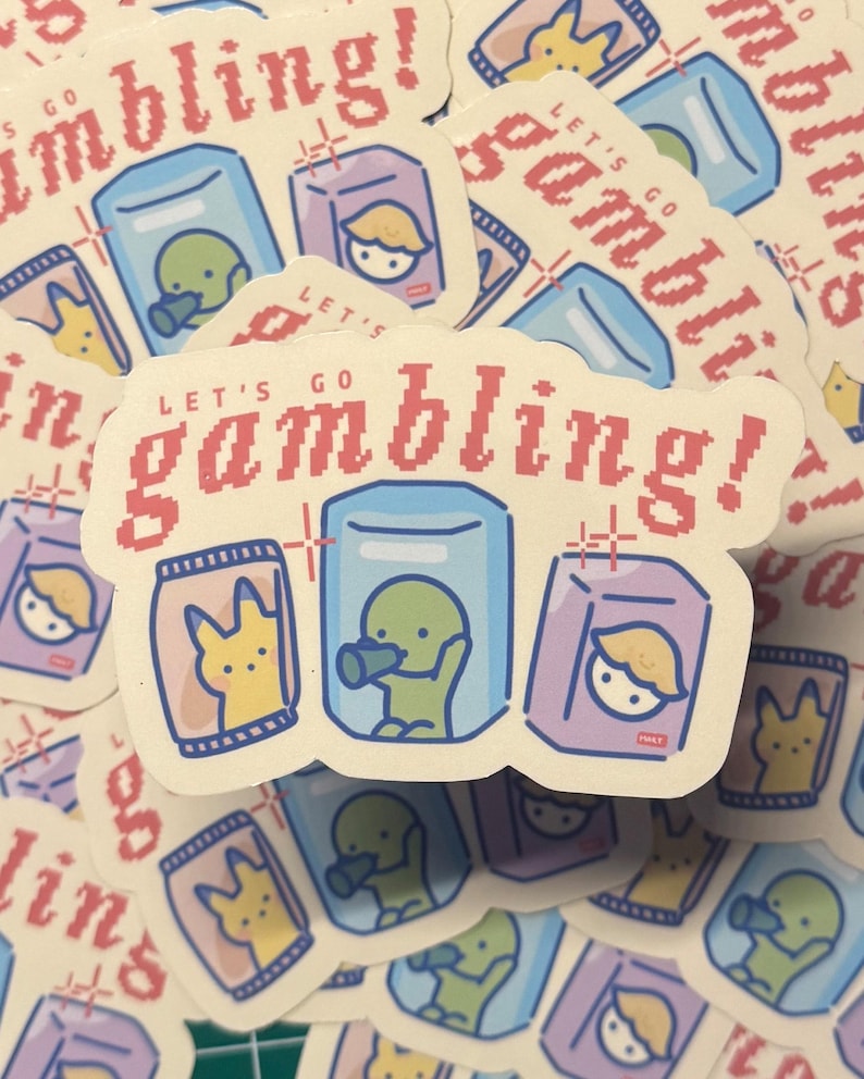 Puede incluir: Una pila de pegatinas con un dise&ntilde;o de dibujos animados. Las pegatinas presentan un fondo amarillo claro con un texto pixelado rojo que dice "Let's go gambling!" Las pegatinas tienen un dise&ntilde;o de dibujos animados de una criatura verde, una criatura amarilla y una persona rubia en una caja.