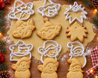 May include: A set of six white plastic cookie cutters and six corresponding baked sugar cookies shaped like holiday characters including an elf, a star, and a figure with a hat, arranged on a flat sheet of unbaked cookie dough.