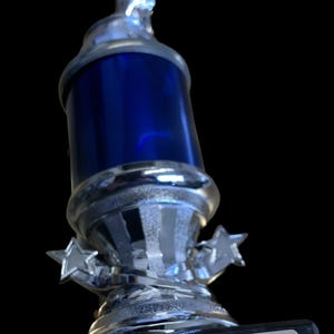 K&ouml;nnte beinhalten: Eine silberne Troph&auml;e mit blauem Mittelteil und Sternakzenten. Der Sockel der Troph&auml;e tr&auml;gt eine Plakette mit der Aufschrift "BKA Bushidokai Karate Academy Student of The Month."