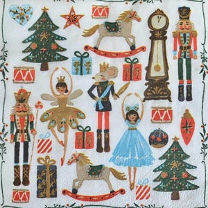 May include: A white napkin with a festive Christmas design. The design includes illustrations of nutcrackers, toy soldiers, ballerinas, rocking horses, wrapped gifts, Christmas trees, and a grandfather clock. The border features a green and red floral pattern.