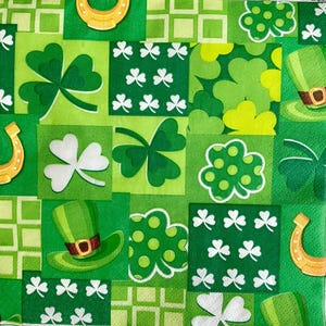 May include: Green and white patterned fabric with shamrocks, horseshoes, and hats. The fabric has a patchwork design with different patterns and colors.