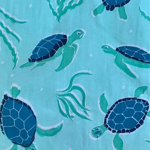 May include: A light blue background with a repeating pattern of green seaweed and blue sea turtles. The turtles are swimming in different directions.