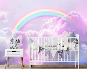 May include: A white crib with a rainbow and cloud themed mural. The crib is decorated with a white, gray, and pink bunting. There are stuffed animals inside the crib, including a gray elephant.