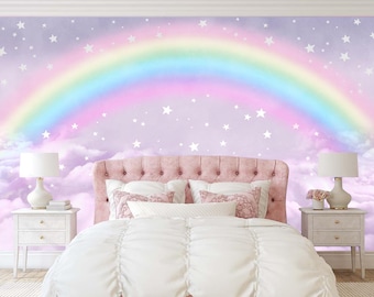 May include: A white bed with a pink headboard and white bedding. The wall behind the bed is painted a light purple and features a rainbow and white stars.