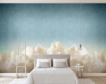 Puede incluir: Un dormitorio con una cama blanca y un papel tapiz de nubes azul claro y blanco. El papel tapiz presenta un degradado de azul que se funde en nubes blancas.