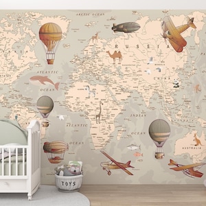 Peut inclure: Une chambre d'enfant avec une carte du monde murale représentant des montgolfières, des avions et des dirigeables. Un lit bébé blanc avec une tête de lit verte est devant la carte. Un éléphant en peluche et un panier à jouets sont également dans la pièce.