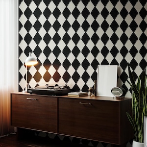 Puede incluir: Un salón de estilo retro con un mueble de madera oscura, un tocadiscos y una lámpara blanca. La pared está decorada con un patrón de diamantes en blanco y negro. Un cuadro enmarcado y un reloj están sobre el mueble.