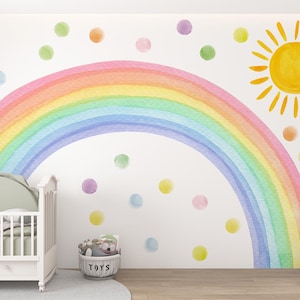 Peut inclure: Une chambre d'enfant avec un lit bébé blanc, un arc-en-ciel et un soleil peints sur le mur, et un éléphant en peluche. L'arc-en-ciel est de couleurs pastel, et le soleil est jaune. Des pois colorés sont dispersés dans la pièce.