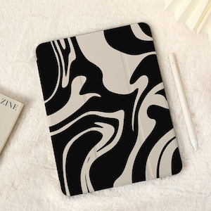 May include: An iPad case with a marbled design in black and beige. The case has a smooth, matte finish.