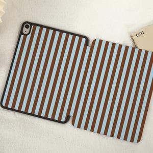 Op de afbeelding: Een iPad-hoes met blauwe en bruine strepen en een zwarte rand.