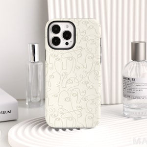 Könnte beinhalten: Eine weiße iPhone-Hülle mit minimalistischem Design, das abstrakte Linienzeichnungen von Gesichtern zeigt. Die Hülle hat einen schwarzen Kamerabuckel und einen schwarzen Rand an den Kanten.
