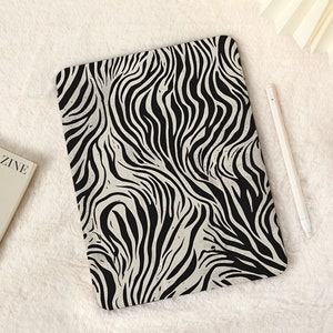 May include: A black and white zebra print iPad case. The case is made of a soft, durable material and has a sleek, modern design.