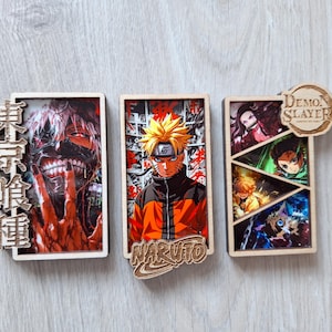 Peut inclure: Trois pièces d'art mural en bois sur le thème des animés. La première présente un personnage avec du texte en japonais. La seconde a un personnage avec le mot "NARUTO". La troisième a plusieurs personnages et les mots "Demon Slayer".
