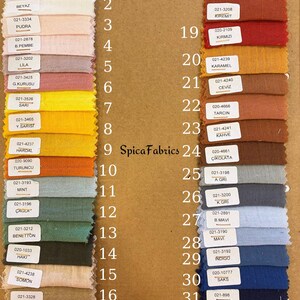 May include: A fabric swatch chart featuring 32 color samples. The swatches are arranged in rows and columns, showcasing a variety of hues, including white, pink, yellow, orange, green, blue, and brown. Each swatch has a corresponding number and color name.