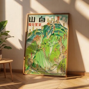 Peut inclure: Une affiche verticale encadrée présentant une carte topographique détaillée d'une chaîne de montagnes dans des tons de vert, marron et bleu. L'illustration comprend des caractères, des étiquettes et des symboles en japonais.