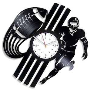 Könnte beinhalten: Schwarz-weiße Schallplattenuhr mit einem Footballspieler, der mit einem Football rennt, und einem Football-förmigen Design. Das Zifferblatt der Uhr ist weiß mit schwarzen Zahlen und Zeigern.