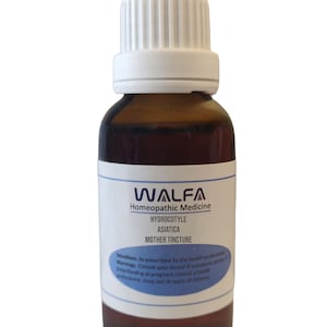 Op de afbeelding: Een bruine glazen fles met een witte dop, met het label "WALFA Homeopathische Geneeskunde HYDROCOTYLE ASIATICA MOEDERTINCTUUR". Het label bevat ook instructies en waarschuwingen voor gebruik.