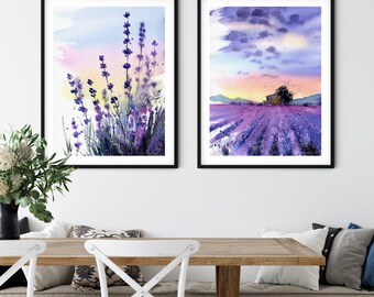 Puede incluir: Dos acuarelas enmarcadas de campos de lavanda. La primera pintura muestra un primer plano de flores de lavanda con un fondo de puesta de sol suave y colorido. La segunda pintura muestra un campo de lavanda con una pequeña casa en la distancia y un cielo nublado.