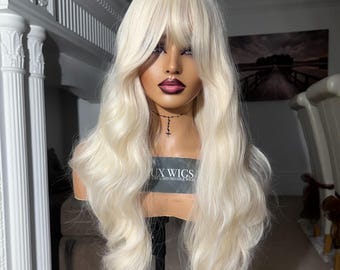 Sandra. Platinablond peruk med fransar. Blond vågig peruk. Vågig blond peruk. 62 cm lång. Platinablond peruk för kvinnor.