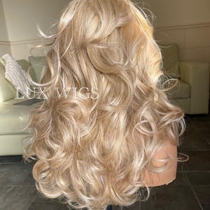 May include: A long, blonde wig with loose curls. The wig is styled with a side part and the curls are cascading down the back.