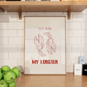 Op de afbeelding: Een witte ingelijste print met de tekst "You are my lobster" in rode letters. Twee rode kreeften tekeningen bevinden zich boven de tekst.