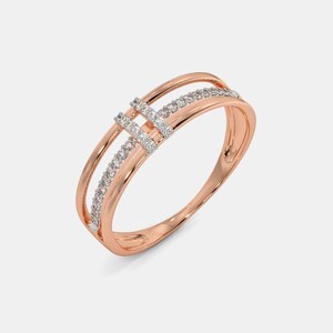 Peut inclure: Une bague en or rose présentant un design à anneau divisé avec deux bandes parallèles reliées par un pont central. Le pont et l'une des bandes sont incrustés de petites pierres claires taillées en rond, offrant un aspect délicat et raffiné.