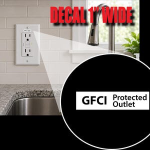 May include: A rectangular white decal measuring 1 inch wide with black text that reads GFCI Protected Outlet. The decal is applied to the top center of a white electrical wall plate featuring two vertical outlets and a small green indicator light.