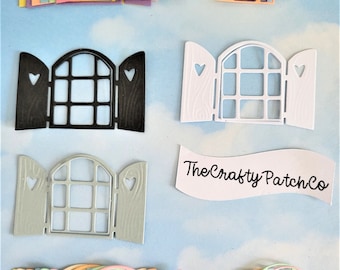 Puede incluir: Un conjunto de 10 formas de ventanas y puertas troqueladas en varios colores pastel, incluyendo rosa, azul, amarillo y verde. Las formas están superpuestas y presentan un recorte en forma de corazón a cada lado. Los troqueles son perfectos para manualidades y scrapbooking.
