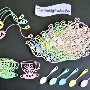 May include: A set of pastel-coloured paper teacups, teapot, and spoons with intricate cut-out designs. The teacups and teapot are stacked, and the spoons are arranged in a row. The text "The Crafty Patch Co." is visible on a piece of paper.