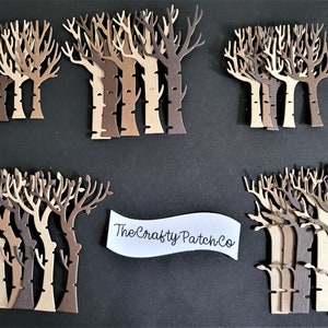 May include: A set of 20 laser-cut wooden trees in various shades of brown. The trees are arranged in four groups of five trees each. The trees are all the same size and shape, but they are different shades of brown. The trees are ideal for adding a touch of nature to your craft projects.