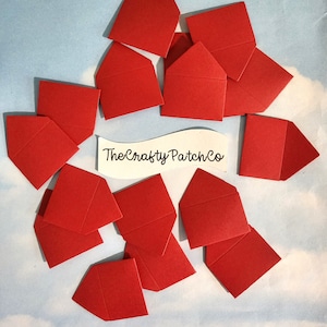 May include: A collection of 15 red mini envelopes, folded and ready to be used for small gifts or notes. The envelopes are arranged on a light blue background with a white label that reads "The Crafty Patch Co."