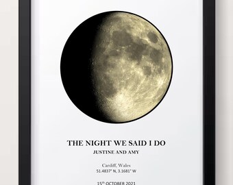 May include: A framed print featuring a detailed depiction of the moon's surface. The text "THE NIGHT WE SAID I DO" is above the names "JUSTINE AND AMY". Below, it lists Cardiff, Wales, coordinates, and the date, October 15th, 2021.