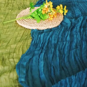 Op de afbeelding: Een geweven strooien placemat met een boeket gele bloemen erop. De placemat ligt op een groene en blauwe stoffen achtergrond.