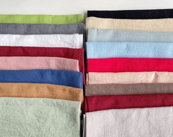 May include: A stack of 18 fabric swatches in various colours and textures, including green, grey, white, red, pink, blue, brown, and beige.