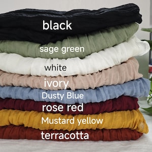 以下が含まれることがあります： 黒、セージグリーン、白、アイボリー、ダスティブルー、ローズレッド、マスタードイエロー、テラコッタなど、さまざまな色のファブリックスワッチが8枚重ねられています。