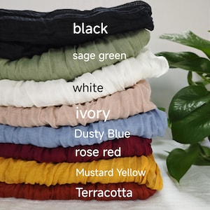May include: A stack of eight fabric swatches in various colours, including black, sage green, white, ivory, dusty blue, rose red, mustard yellow, and terracotta.