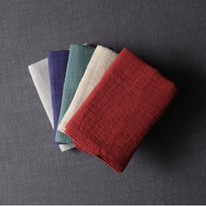 May include: Five folded fabric squares in different colors: gray, navy blue, teal, beige, and burgundy.