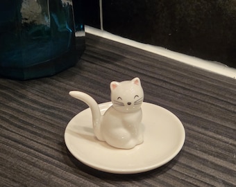 Plato de baratijas con cara de gato blanco sentado